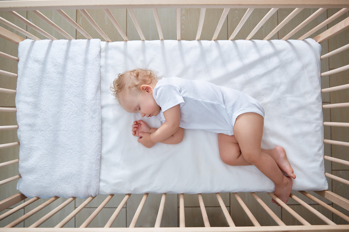 Bebé a dormir tranquilamente no berço numa noite quente de Verão